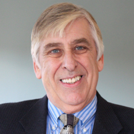 Headshot of Adrian Bishop. He has grey hair and wears a blue striped shirt and suit.