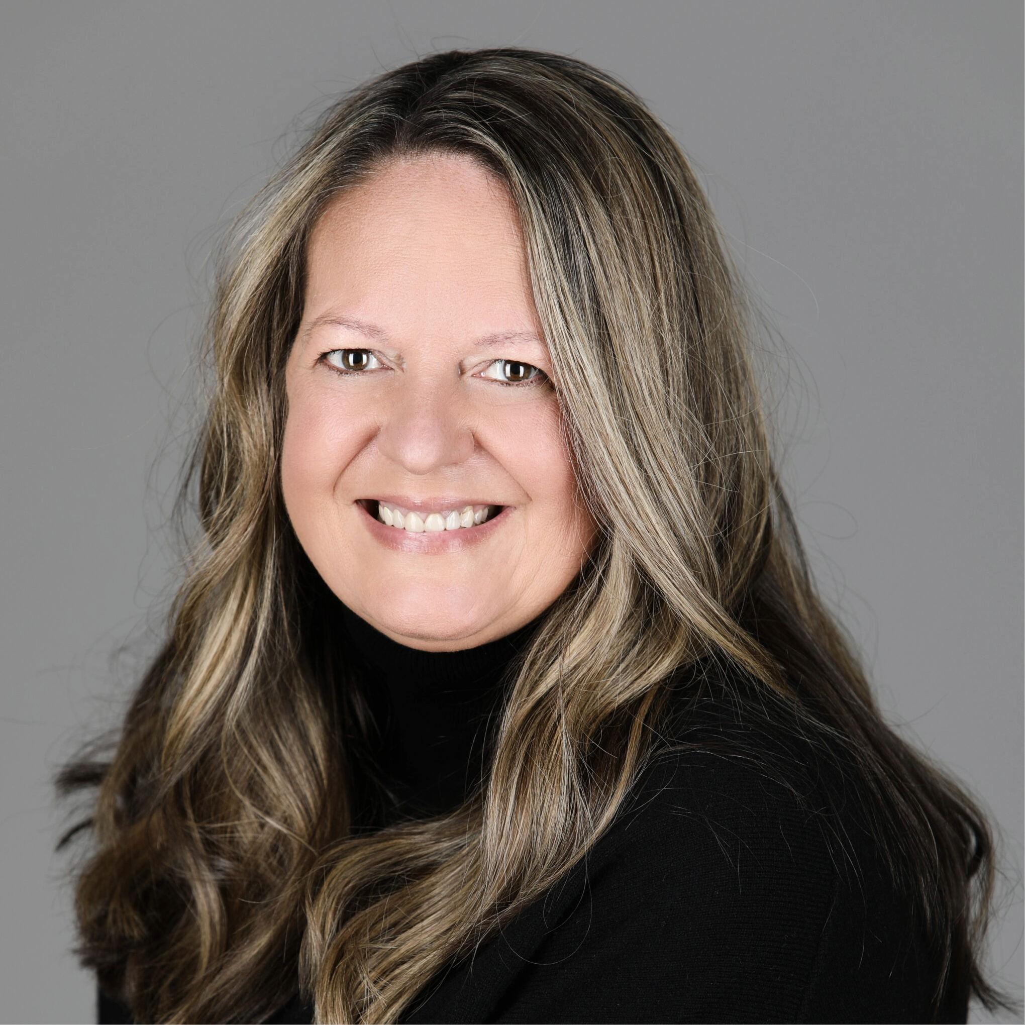 Terri Tobin smiles at the camera. She wears a black sweater and has dirty blonde hair.